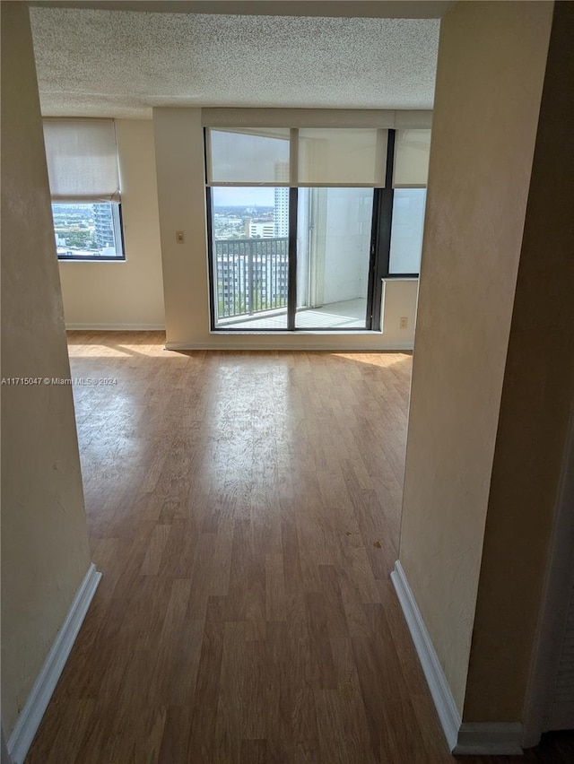 empty room with a textured ceiling and hardwood / wood-style flooring