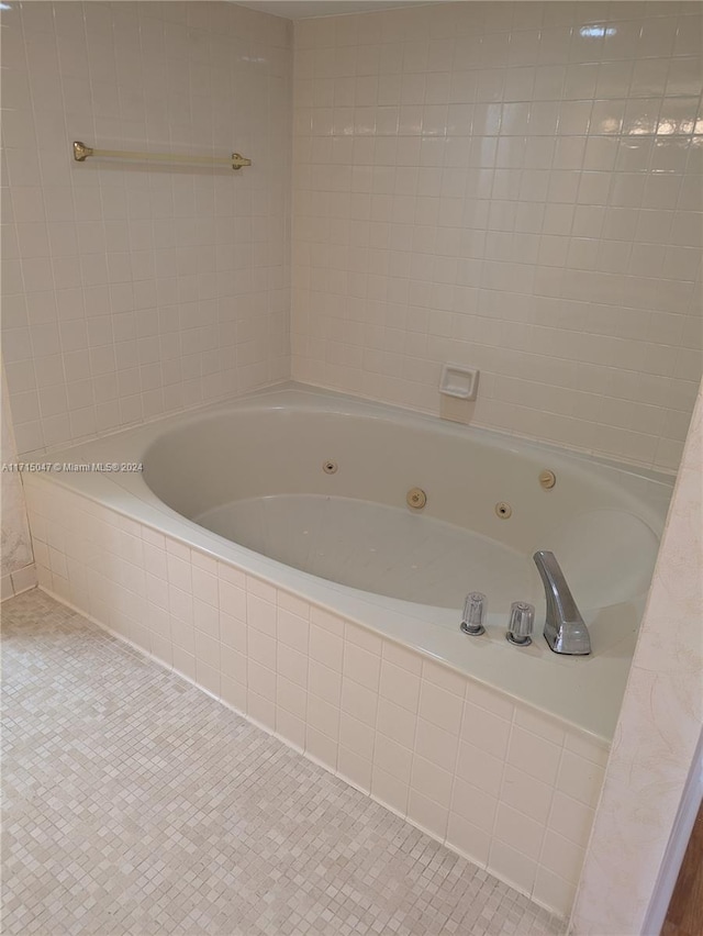 bathroom with tile patterned floors and tiled tub