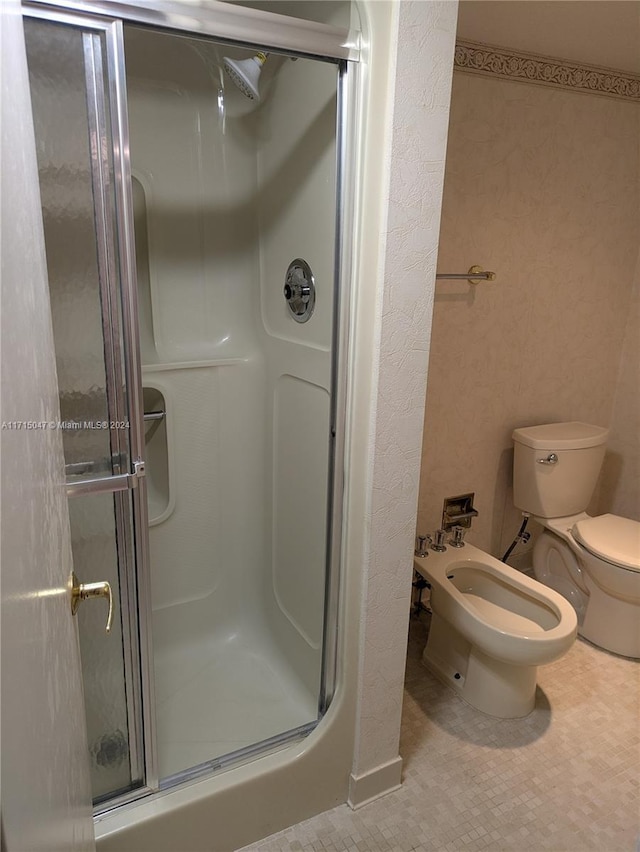 bathroom featuring a bidet, a shower with shower door, and toilet