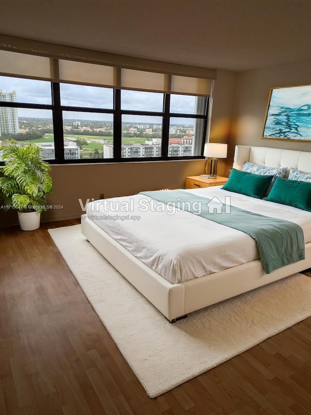 bedroom with hardwood / wood-style flooring and multiple windows