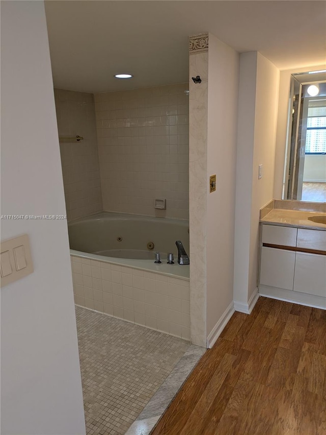 bathroom featuring hardwood / wood-style floors, vanity, and tiled shower / bath combo