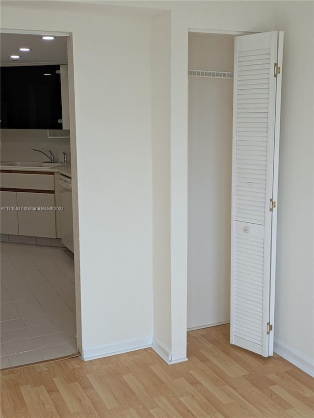 unfurnished bedroom with light wood-type flooring, sink, and a closet