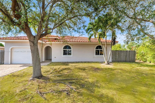 mediterranean / spanish-style house featuring a front lawn and a garage