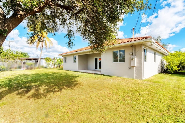 rear view of property with a lawn