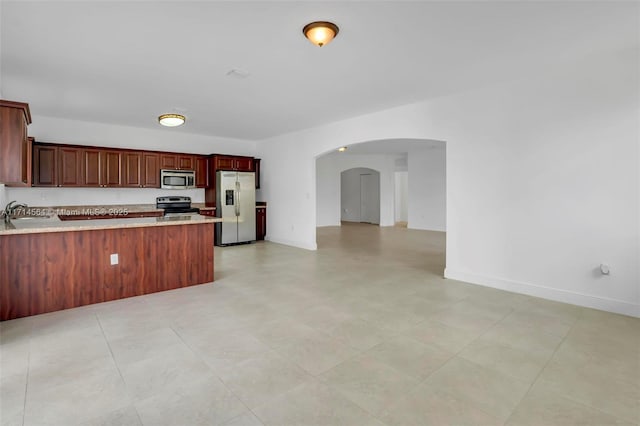 kitchen with a kitchen bar, sink, appliances with stainless steel finishes, and kitchen peninsula