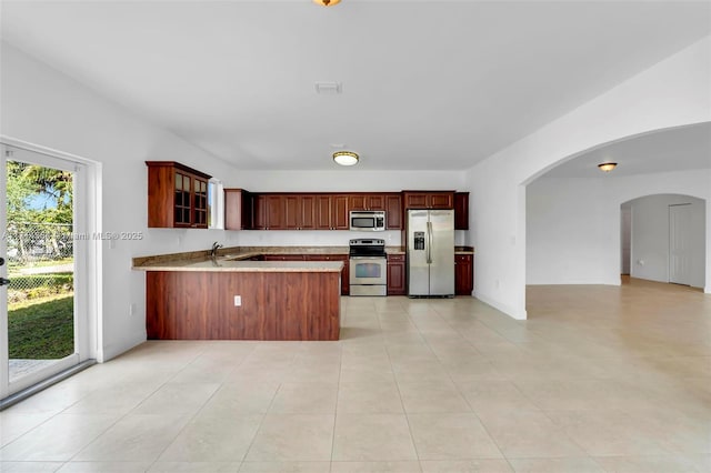 kitchen featuring appliances with stainless steel finishes, kitchen peninsula, and light tile patterned flooring