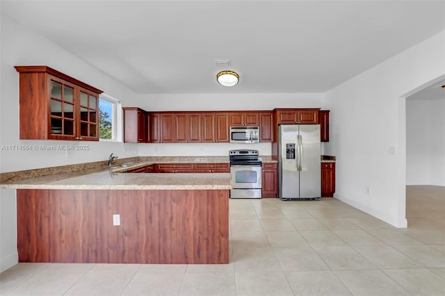 kitchen with light tile patterned flooring, stainless steel appliances, kitchen peninsula, and sink