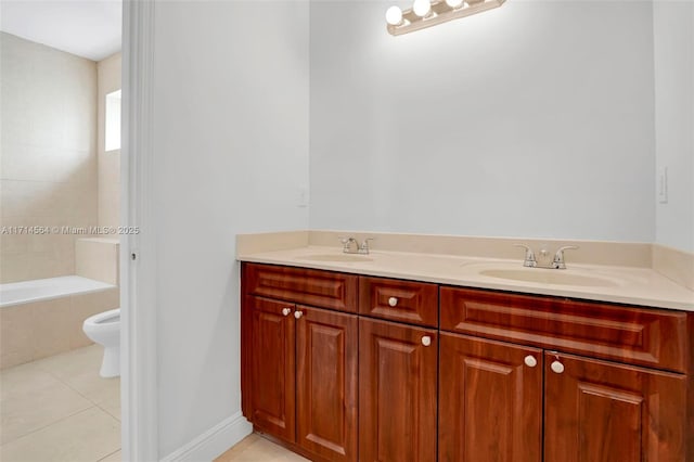 bathroom with toilet, vanity, a tub, and tile patterned floors