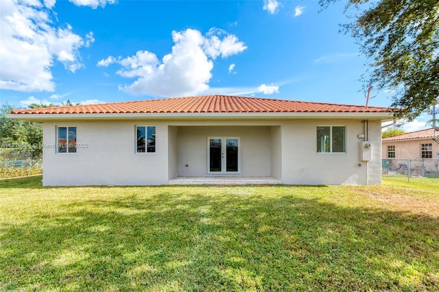 rear view of property featuring a patio area and a lawn