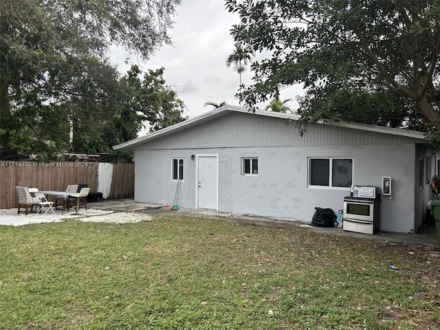 rear view of property with a patio area and a lawn