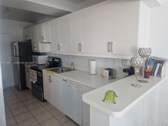 kitchen featuring white appliances, kitchen peninsula, light tile patterned floors, tasteful backsplash, and white cabinetry