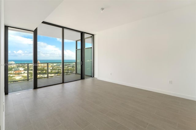 empty room featuring a water view and floor to ceiling windows