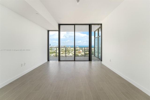 spare room featuring hardwood / wood-style floors and floor to ceiling windows