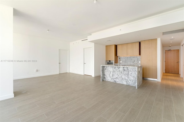 unfurnished living room featuring sink