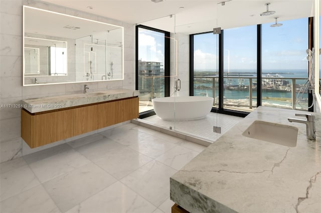 bathroom with separate shower and tub, expansive windows, vanity, and a water view