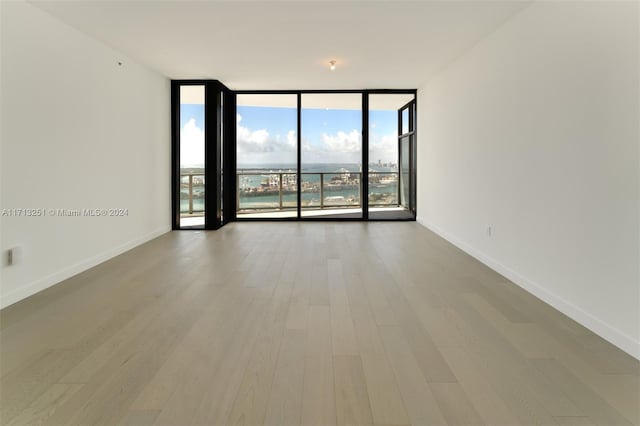 empty room featuring floor to ceiling windows and hardwood / wood-style floors