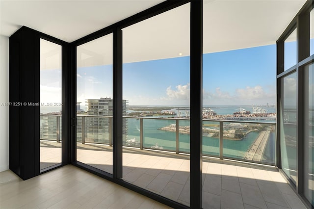 entryway featuring floor to ceiling windows, a water view, and a healthy amount of sunlight