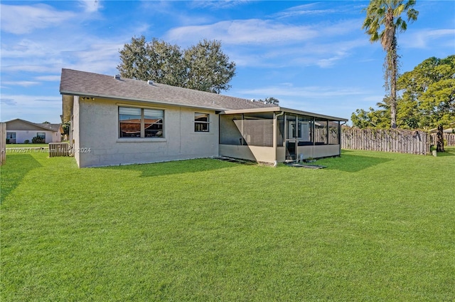 back of house with a sunroom and a lawn