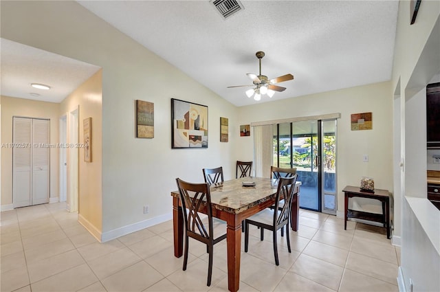 dining area featuring a textured ceiling, ceiling fan, light tile patterned flooring, and lofted ceiling