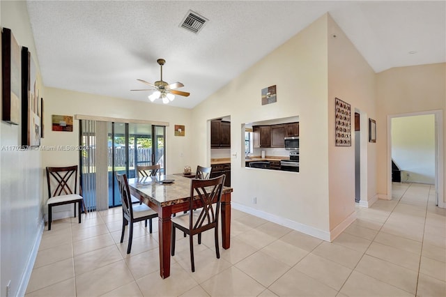 dining area featuring a textured ceiling, ceiling fan, light tile patterned flooring, and lofted ceiling