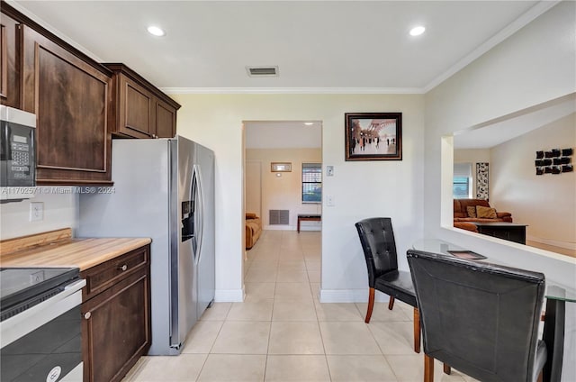 kitchen with dark brown cabinetry, crown molding, plenty of natural light, and appliances with stainless steel finishes