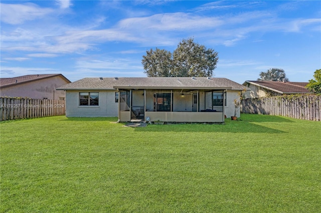 rear view of house featuring a lawn and a sunroom