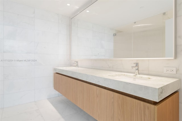 bathroom with vanity and tile walls