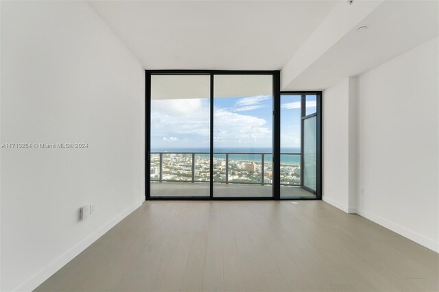500 Alton Rd Unit 3905, Miami Beach, FL 33139 - empty room with a wall of windows, a water view, and wood finished floors