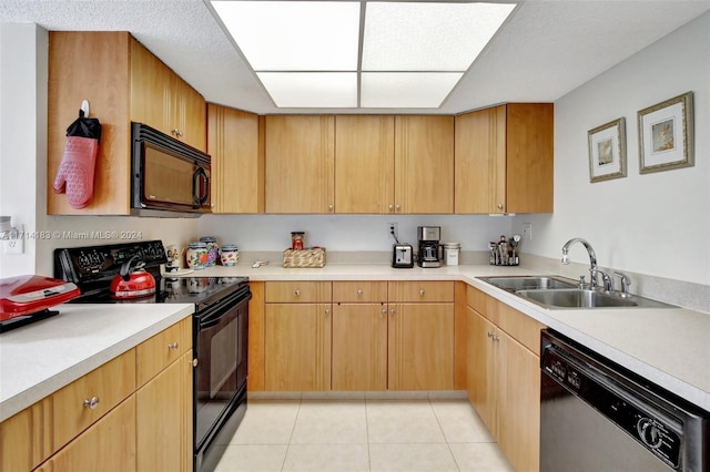 kitchen with light tile patterned flooring, sink, and black appliances