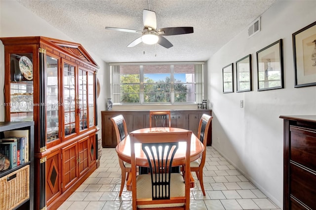 dining area with ceiling fan, light tile patterned floors, and a textured ceiling