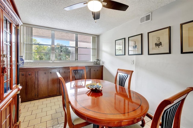 tiled dining area featuring a textured ceiling and ceiling fan