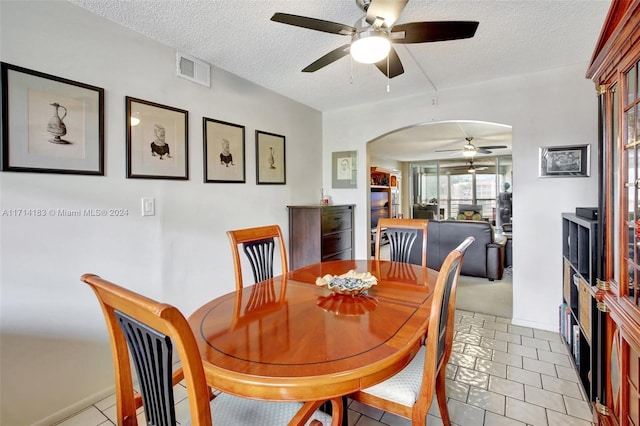 tiled dining room featuring ceiling fan and a textured ceiling