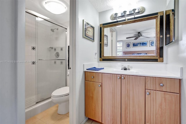 bathroom with vanity, tile patterned flooring, ceiling fan, toilet, and a textured ceiling