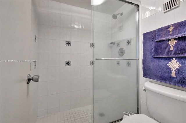 bathroom with toilet and an enclosed shower