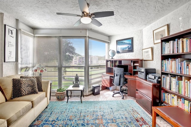 carpeted home office with ceiling fan and a textured ceiling