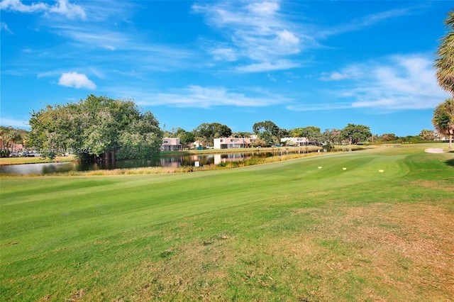 view of home's community with a water view and a yard