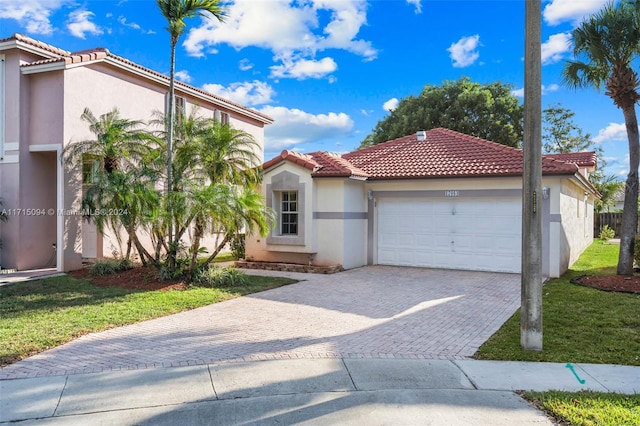 mediterranean / spanish-style house featuring a garage and a front yard