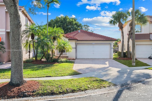 mediterranean / spanish home with a front lawn and a garage