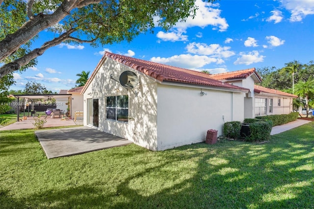 back of house featuring a patio area and a yard