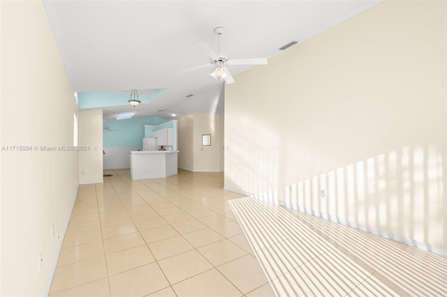 corridor featuring light tile patterned floors and vaulted ceiling