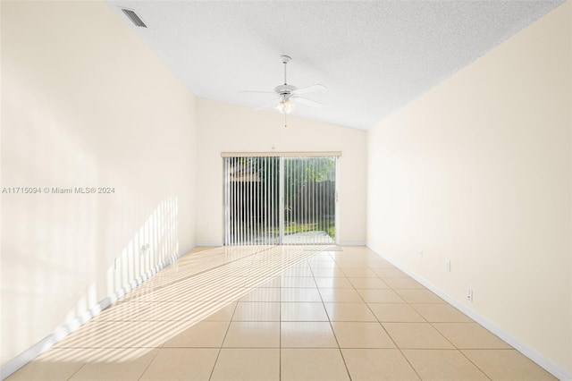 tiled spare room featuring a textured ceiling, vaulted ceiling, and ceiling fan