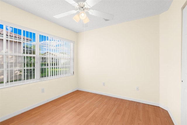 unfurnished room with ceiling fan, a textured ceiling, and hardwood / wood-style flooring