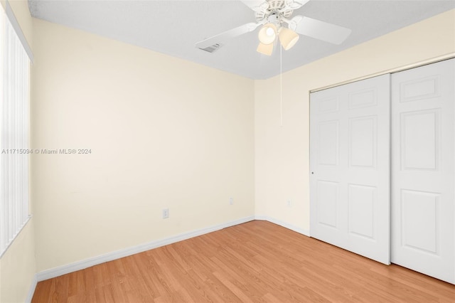 unfurnished bedroom featuring ceiling fan, a closet, and light hardwood / wood-style flooring