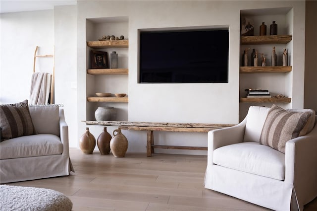 living area featuring light wood-type flooring and built in features