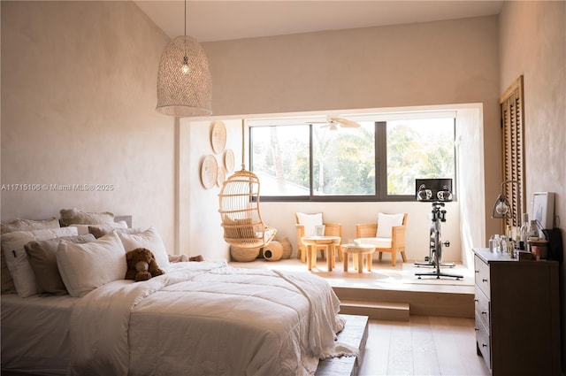 bedroom with lofted ceiling and light hardwood / wood-style floors