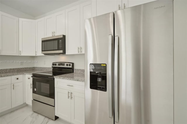 kitchen with white cabinets, light stone counters, and appliances with stainless steel finishes