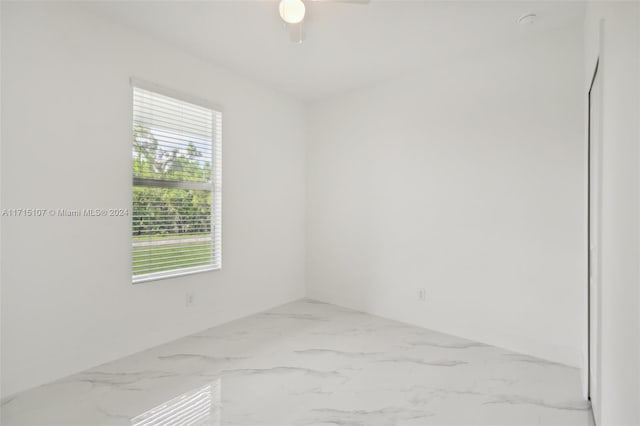 spare room with ceiling fan and plenty of natural light