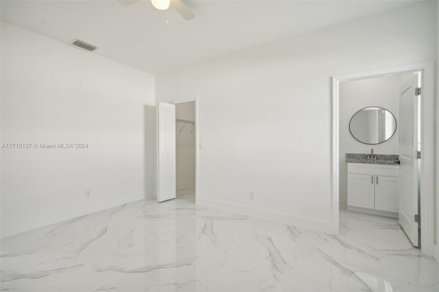 unfurnished room featuring ceiling fan and sink