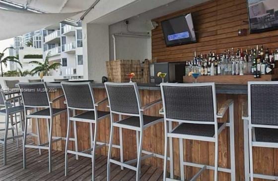 bar with wooden walls and hardwood / wood-style floors