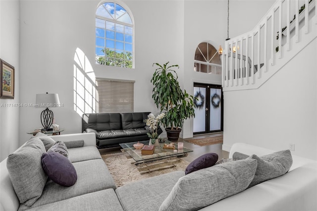 living room with a towering ceiling and a chandelier